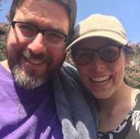 Chris and Hallie smiling at the camera while on a hike